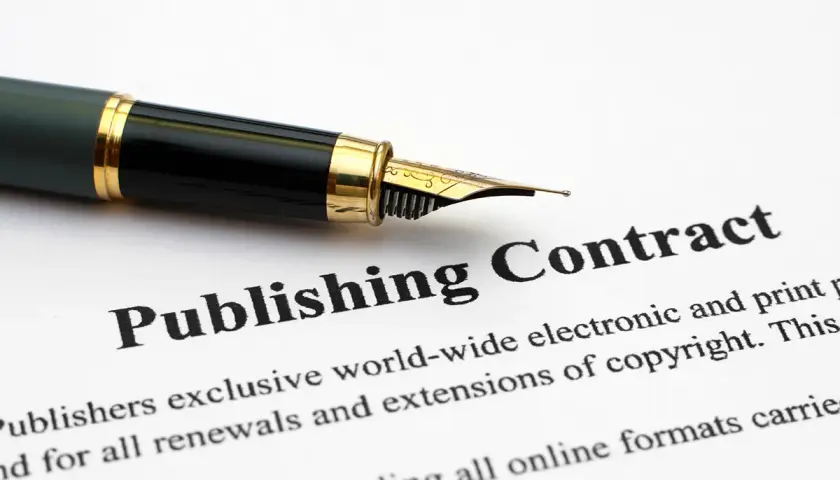 Plume sur un contrat de publication. Un éditeur de livre s'apprête à signer un accord important.