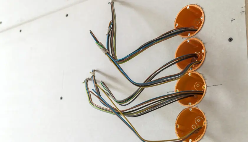 Instalacja elektryczna: prowadzenie kabli po ścianie do puszek instalacyjnych.