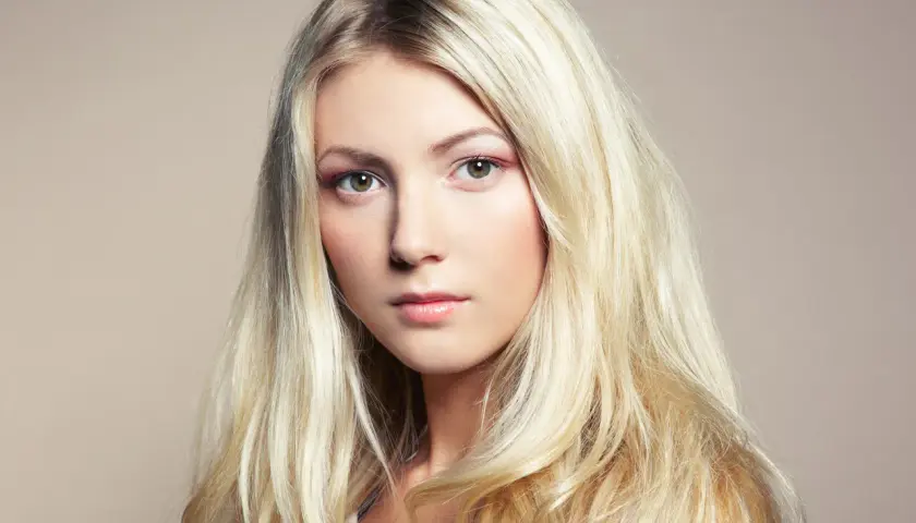 Piękna blondynka z długimi, falowanymi włosami. Poznaj sekrety, jak dbać o blond włosy, by były zdrowe i lśniące.