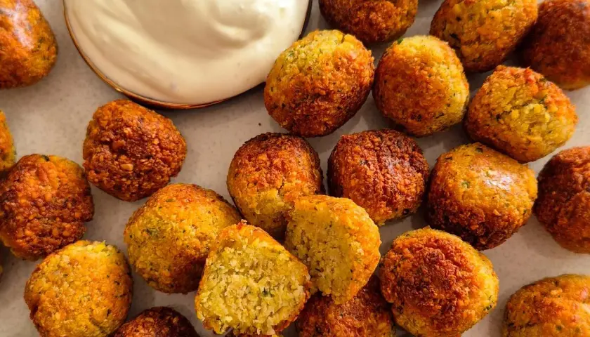 Goldbraune, knusprige Falafel, perfekt für ein veganes Rezept. Dazu cremiger Dip und frische Limette.