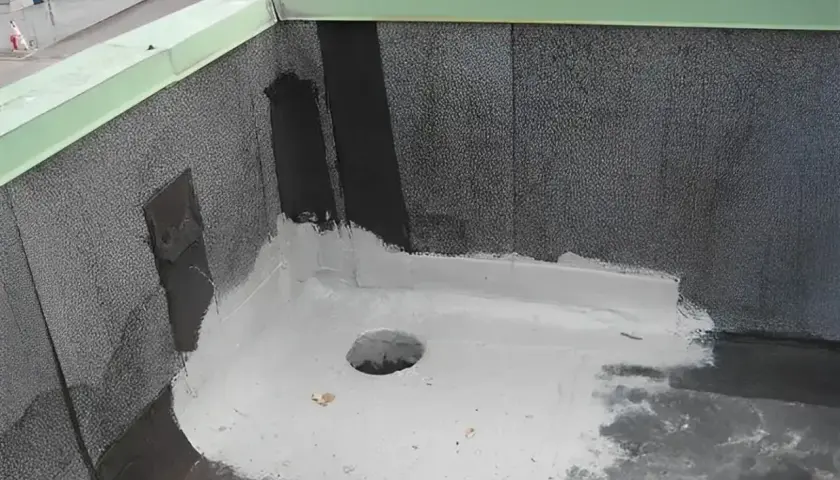 Nowy dach z papy z uszczelnieniem z elastomeru. Widać otwór odpływowy i zieloną attykę.