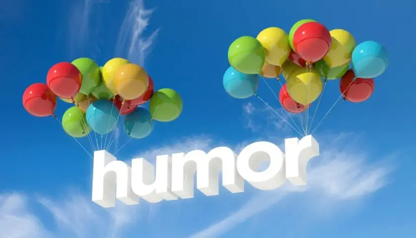 Färgglada ballonger bär upp ordet "humor" i luften. En härlig skrift med humor som svävar mot en blå himmel.