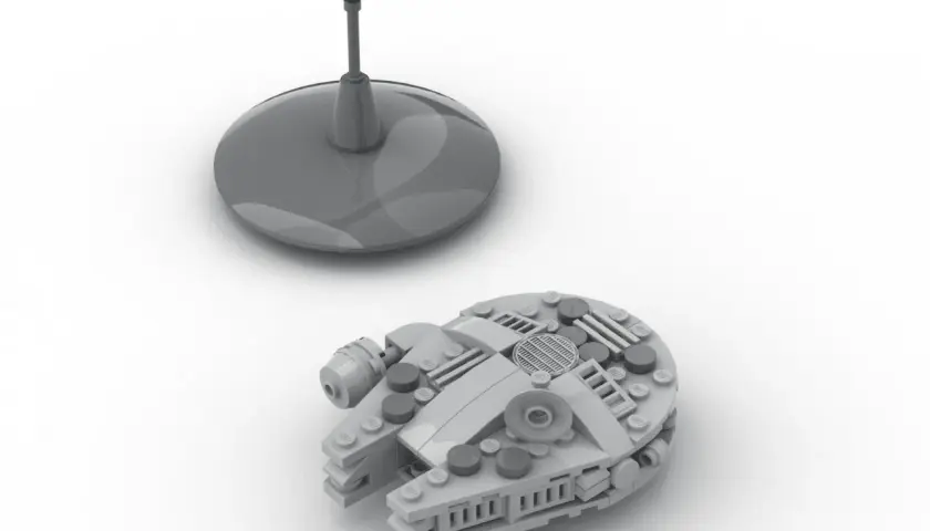 Grauer Lego Millennium Falcon auf weißem Grund, daneben ein Display-Ständer. Die Lego Millennium Falcon Anleitung ist hier zu sehen.