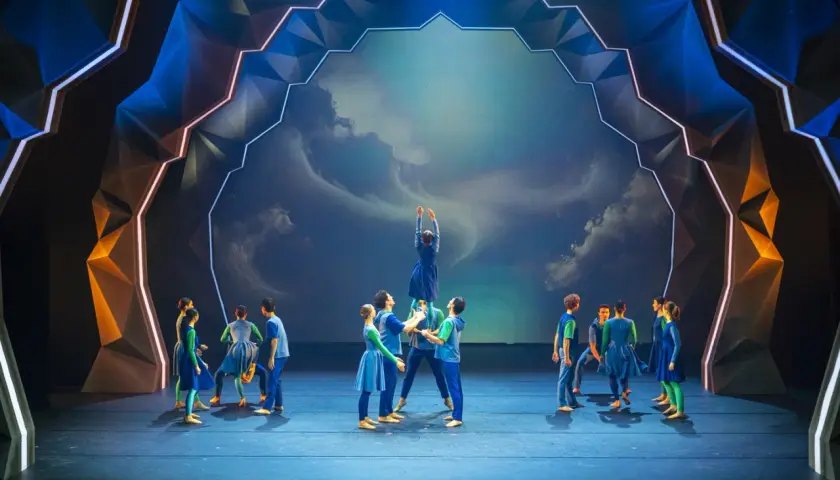 Tancerze na scenie Operetki Wrocławskiej w błękitnych strojach, tworząc żywą piramidę. Spektakularna scenografia.