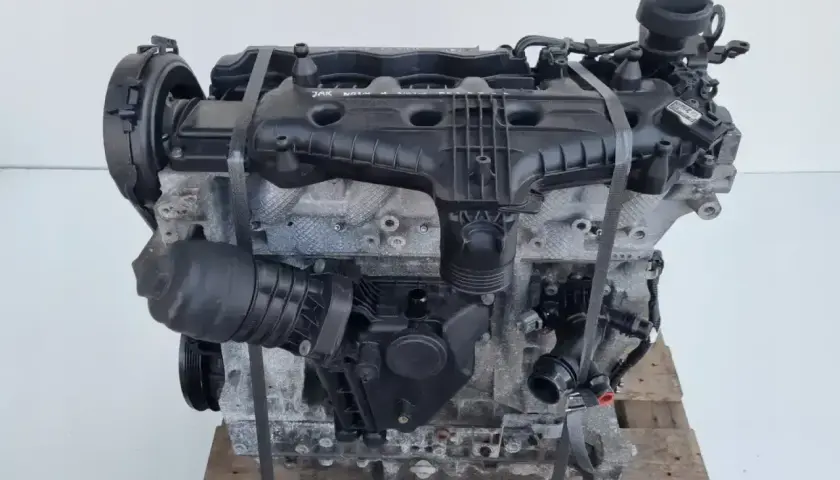 Silnik Volvo T6, gotowy do montażu. Potężna jednostka napędowa z widocznymi elementami osprzętu, umieszczona na drewnianej palecie.