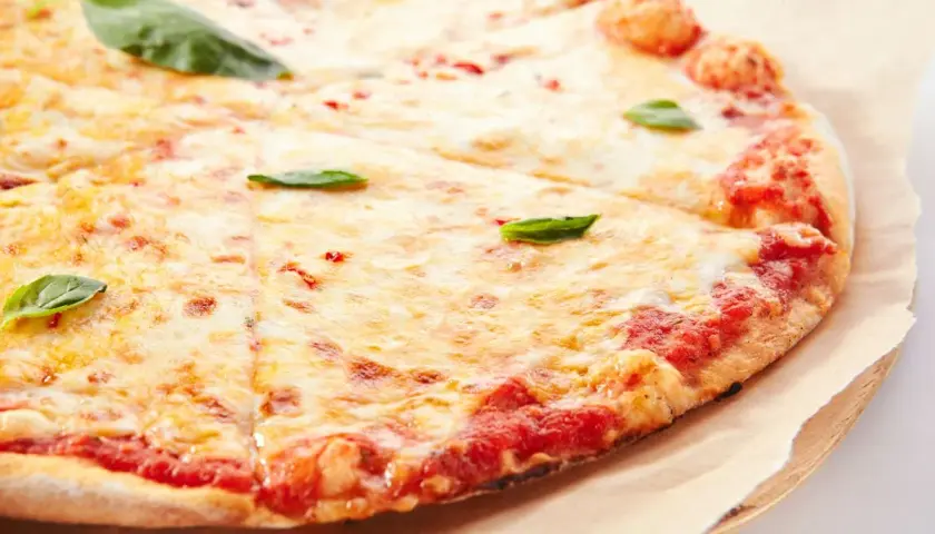 Pizza margherita con lievito istantaneo, croccante e dorata, con abbondante mozzarella filante e basilico fresco.