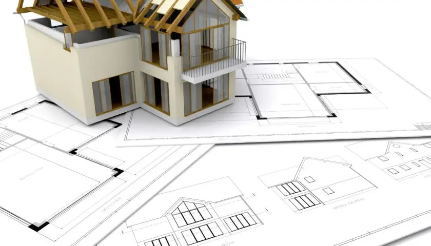 Model domu na planach architektonicznych. Zastanawiasz się, ile trwa budowa domu? To zależy od wielu czynników, ale projekt to pierwszy krok.