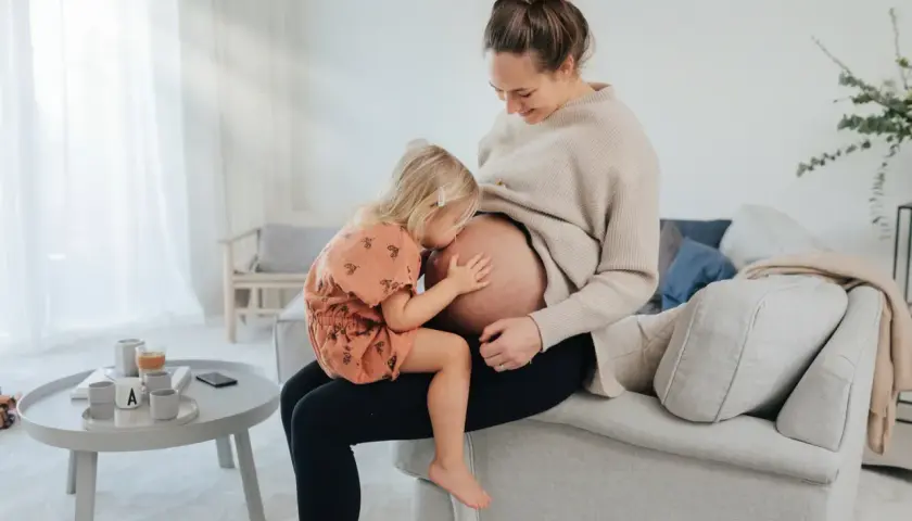Liten flicka kramar sin mammas mage. En fin stund för blivande storasyster, som snart får en lillebror eller lillasyster. Folsyra är viktigt för en frisk graviditet.