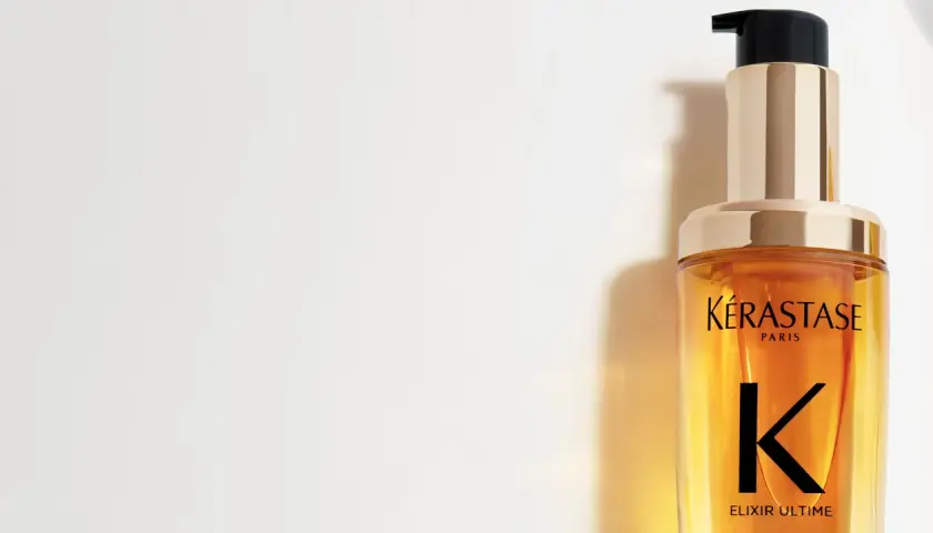 Lyxig flaska med Kérastase Elixir Ultime olja i håret. Ger glans och näring.