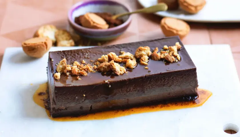 Bonet piemontese al cioccolato, lucido e cremoso, guarnito con briciole croccanti e salsa caramello.