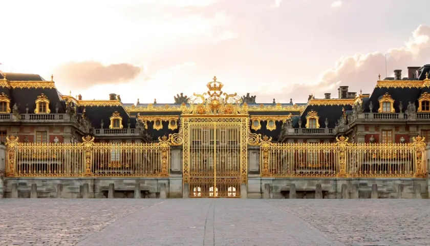Złota brama Pałacu wersal zwiedzanie. Monumentalna fasada z bogatymi zdobieniami i kamiennym brukiem.