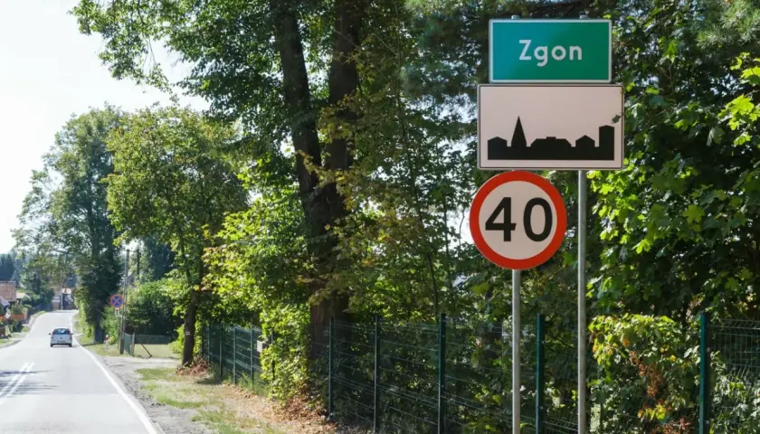 Zielony znak miejscowości Zgoń, obok znak z sylwetką miasta i ograniczenie prędkości do 40 km/h.