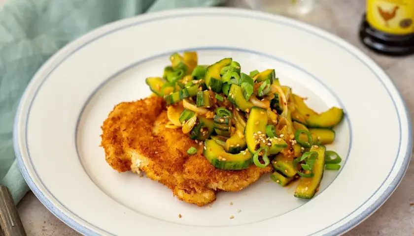 Krispig panerad schnitzel med en fräsch gurksallad toppad med sesamfrön och salladslök. En härlig kombination av texturer och smaker.