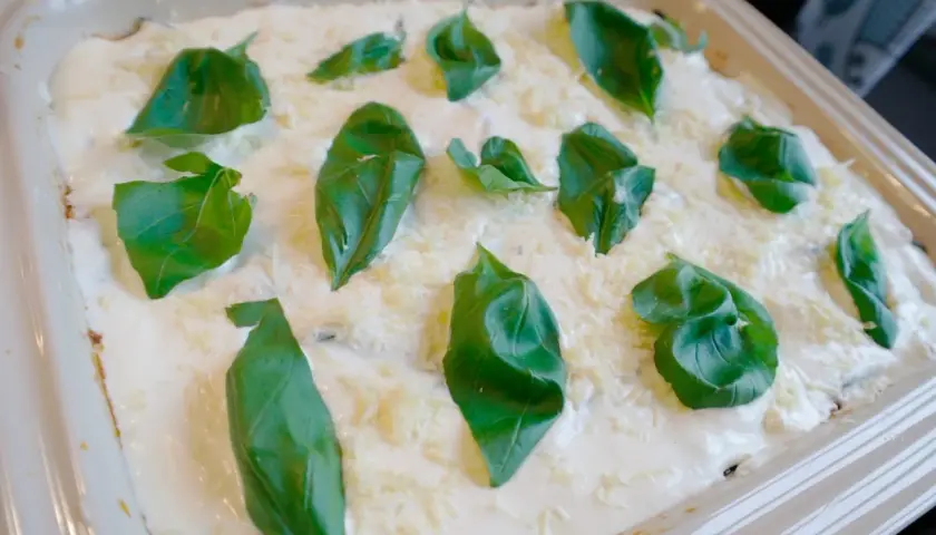 Lasagne med zucchini och fetaost, toppad med krämig ostsås och färsk basilika. En läcker och lätt sommarrätt.