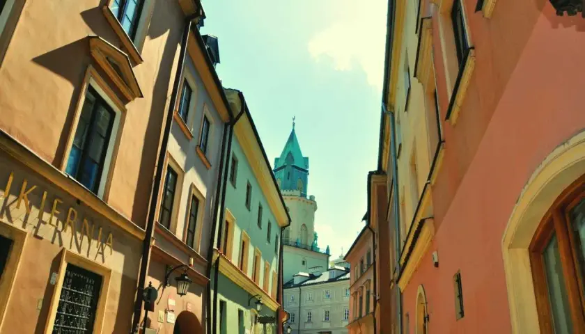 Ulica w Lublinie z kolorowymi kamienicami i wieżą. Może to być początek przygody w parku rozrywki Lublin.