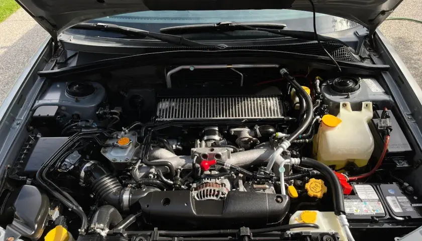 Silnik Subaru z widocznym zbiorniczkiem płynu chłodniczego. Warto sprawdzić, ile litrów płynu wchodzi do chłodnicy, by zapewnić optymalne chłodzenie.