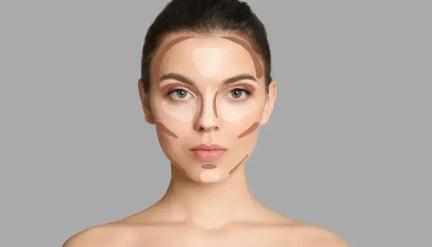 Modelka pokazuje, jak nakładać bronzer i rozświetlacz, tworząc efekt konturowania twarzy.