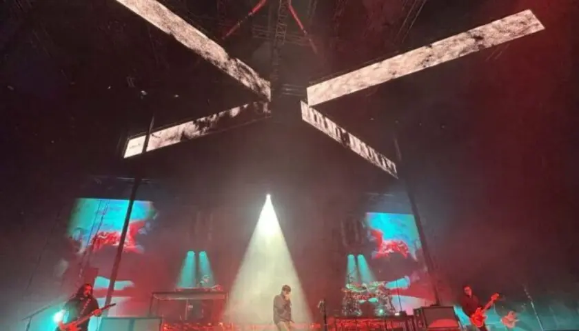 Deftones koncert Polska. Wokalista na scenie, gitarzyści grają, a za nimi ekrany z wizualizacjami.