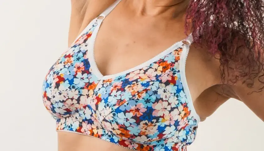 A woman wears a colorful floral bra. This bra pattern is free to download and create your own!