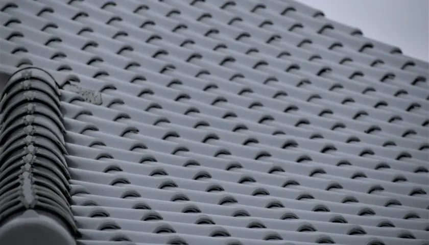 Pokryty śniegiem dach z dachówki ceramicznej. Widać wyraźnie, jaki spadek dachu na 6 metrach, z charakterystycznym grzebieniem na krawędzi.