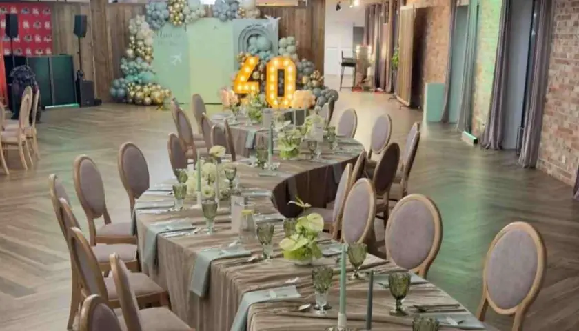 Elegancka sala bankietowa z nakrytymi stołami na 40 osób, balony i podświetlana liczba "40" sugerują, że to miejsce na udaną imprezę.