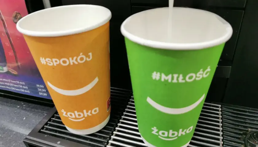 Dwie kawy z Żabki: pomarańczowa z napisem #Spokój i zielona z #Miłość. Duża kawa z Żabki ma 300 ml.