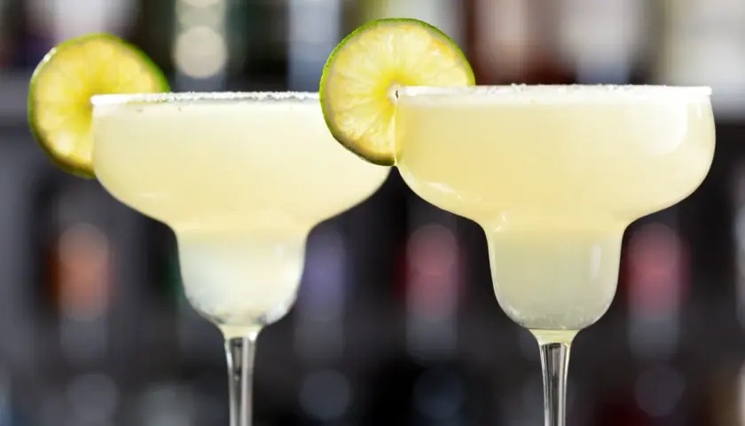 Två frostiga margaritas med saltkant och lime. Perfekt för en varm sommardag.