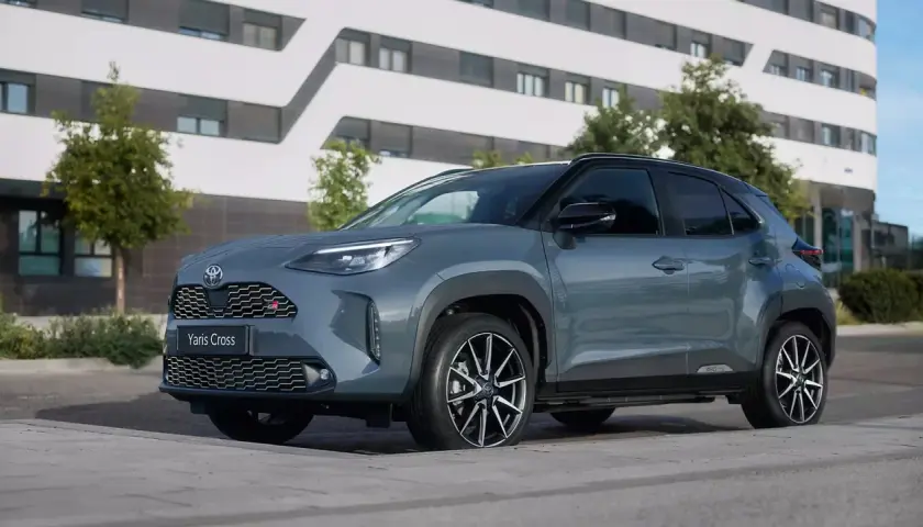 Szary Toyota Yaris Cross GR Sport na tle nowoczesnego budynku. Wiele osób szuka **toyota yaris cross opinie** przed zakupem.