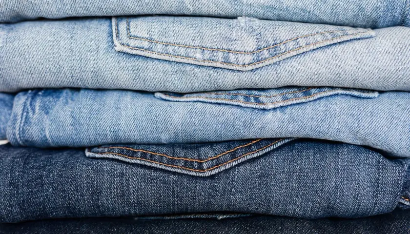 Stos jasnych i ciemnych jeansów. Czy to firma Replay?