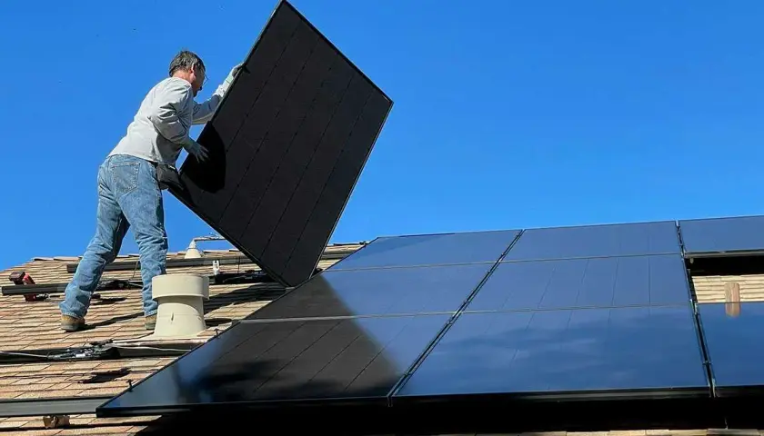 Installatör monterar solceller på taket, ett steg mot ökad solcellshållbarhet och en grönare framtid.