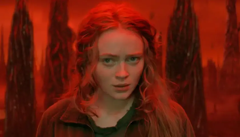 Max, le regard perdu dans le monde inversé de Stranger Things, entourée de formes sombres et menaçantes.
