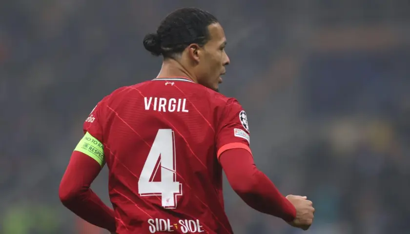 Piłkarz Liverpoolu Virgil van Dijk z numerem 4 na czerwonej koszulce. Na rękawie opaska "No to racism. Respect".