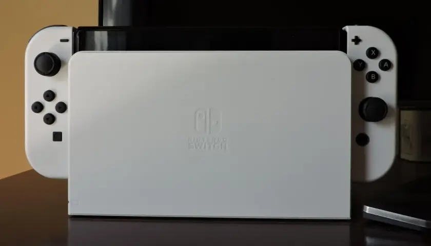 Biały Nintendo Switch z dokiem. Zastanawiasz się, czy da się podłączyć Nintendo Switch do laptopa?