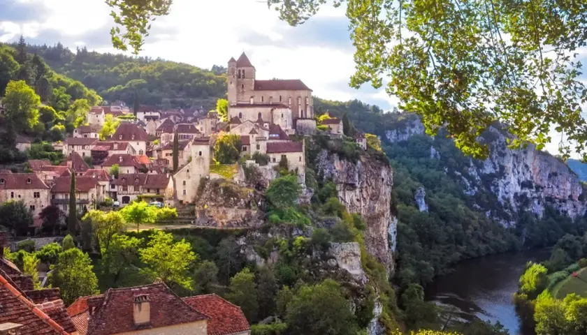 Village médiéval perché sur une falaise, dominant une rivière. Un paysage digne d'un millésime Cahors, où le temps semble s'être arrêté.