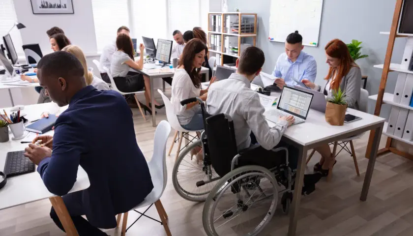 A diverse team collaborates in a modern office, showcasing the evolution of diversity and inclusion in the workplace.