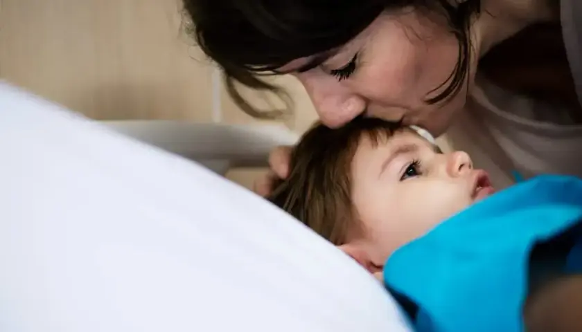Matka całuje dziecko w czoło. Czas oczekiwania na odzyskanie dziecka z rodziny zastępczej bywa długi, ale miłość jest zawsze.