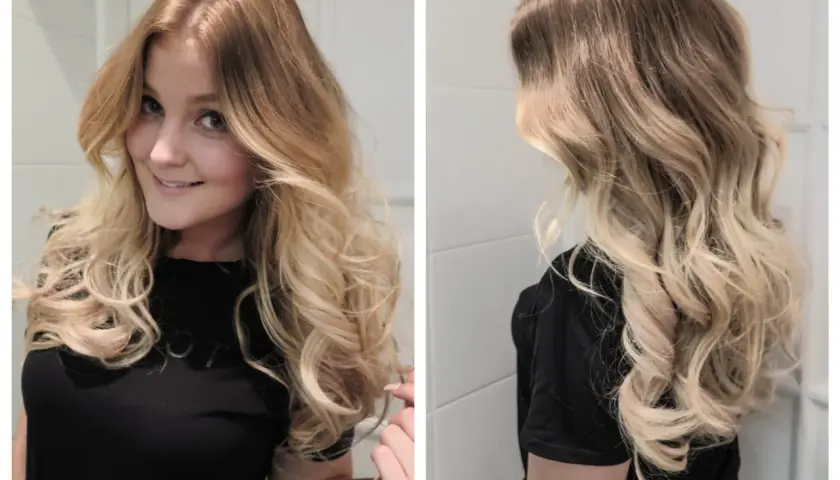 En kvinna med vackra, blonda lockar som ramar in hennes ansikte. Håret är stylat i mjuka vågor.