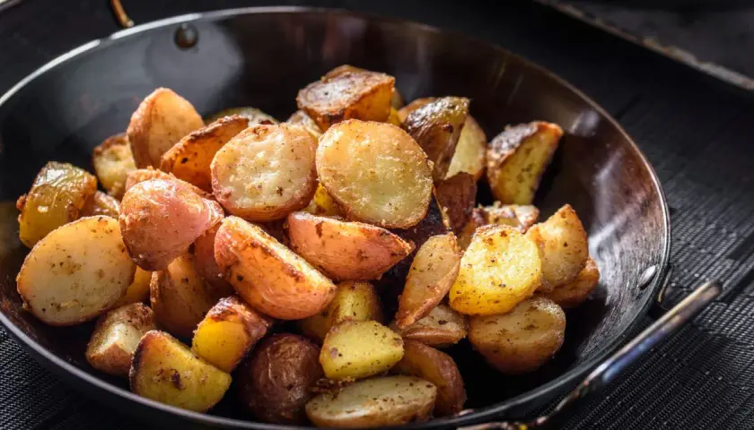Goldbraune bratkartoffeln mit Ei, knusprig gebraten und würzig gewürzt, serviert in einer Pfanne.
