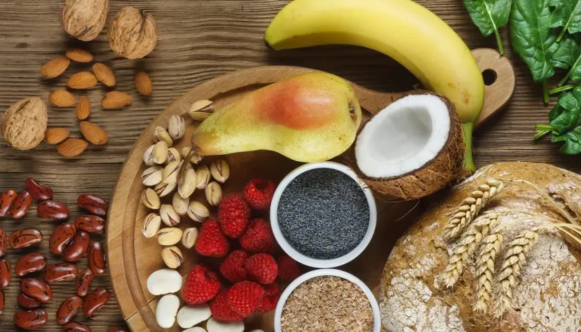 Frutta, noci, semi, legumi e pane integrale: un'abbondanza di cibi ricchi di fibre per una dieta sana.