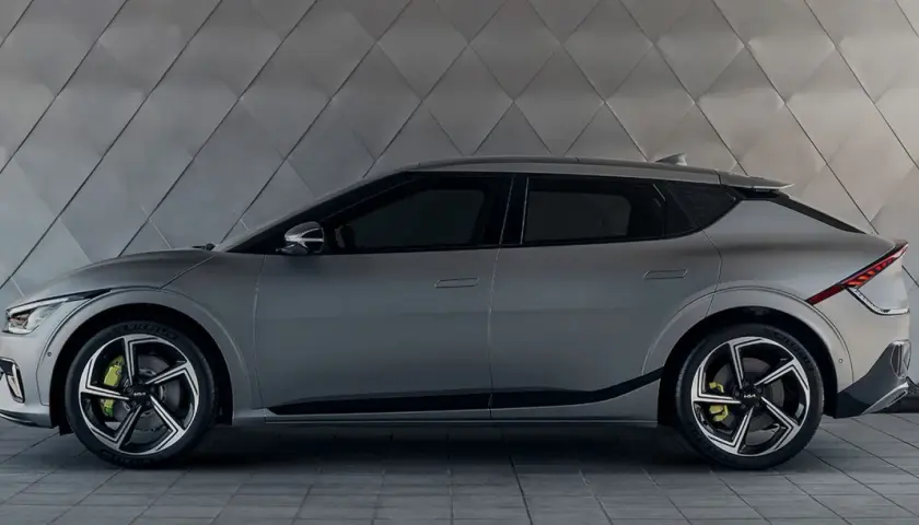 Szary Kia EV6 na tle geometrycznej ściany. Sprawdź atrakcyjną kia ev6 cena i zamów już dziś!
