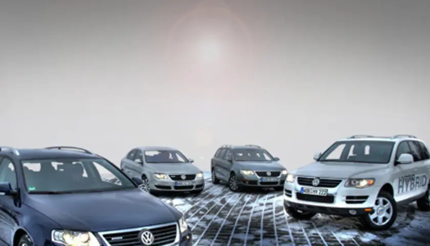 Cztery samochody Volkswagen, w tym jeden z napisem HYBRID, stoją na zaśnieżonej drodze. To pokazuje, co oznacza Bluemotion – ekologiczne i oszczędne rozwiązania.