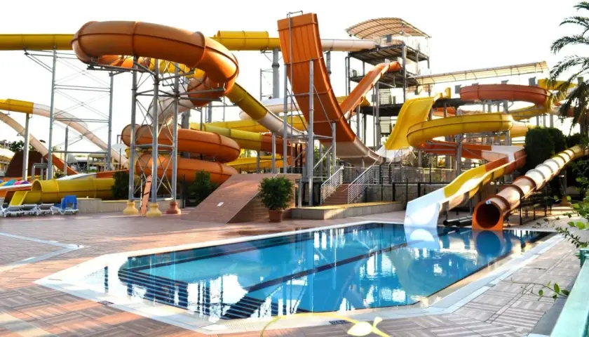 Wodny park rozrywki w Turcji, idealny na upalną pogodę w sierpniu. Kolorowe zjeżdżalnie i basen zapraszają do zabawy.