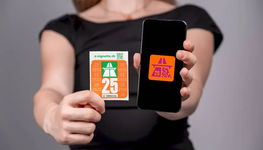 Elektroniczna winieta na szwajcarskie drogi płatne i jej cyfrowy odpowiednik na ekranie smartfona.