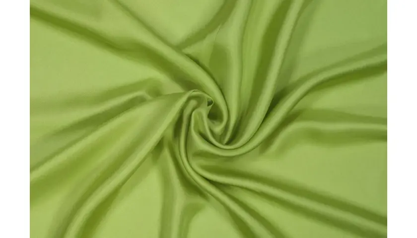 Drapé de tissu sergé vert pomme, doux et soyeux, formant des plis élégants.