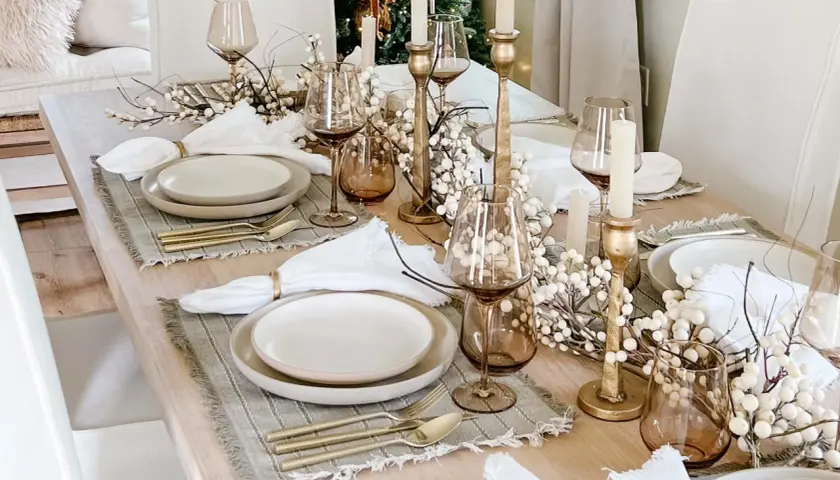 Elegant Christmas tablescapes featuring gold accents, white berry branches, and amber glassware.