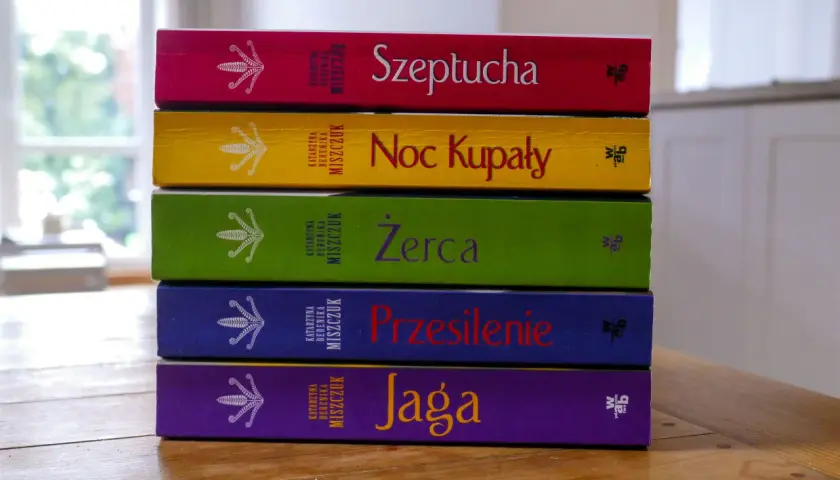 Pięć kolorowych książek Katarzyny Bereniki Miszczuk ułożonych jedna na drugiej. Na okładkach widnieje symbol kwiatu paproci.