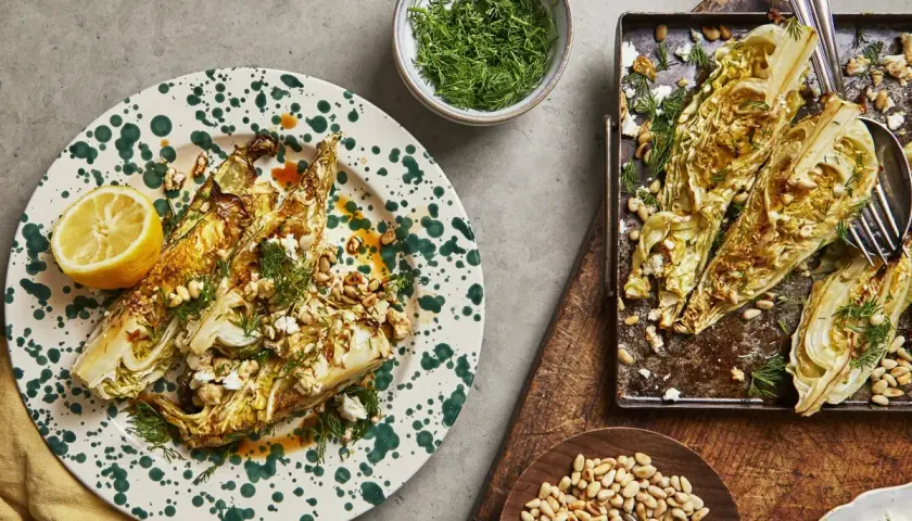 Ugnsbakad spetskål i soja, toppad med fetaost, pinjenötter och dill. Serveras med citronklyfta.