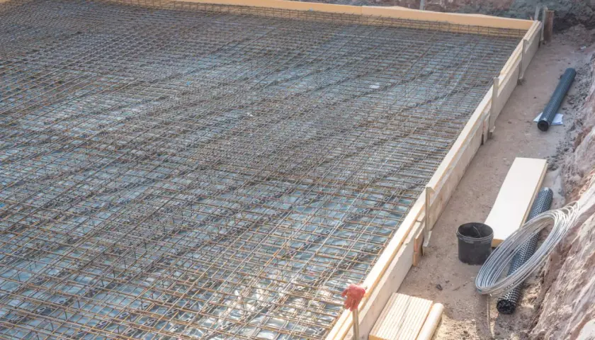 Bewehrung für eine Bodenplatte, vorbereitet in einer einseitige schalung. Stahlmatten liegen bereit für den Beton.