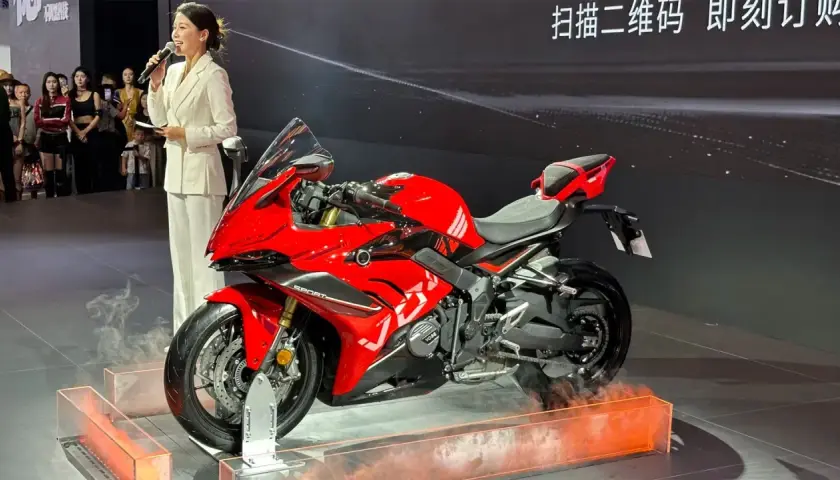 Presentación de la Voge 666 RR, una moto deportiva roja brillante, con una presentadora hablando al micrófono.