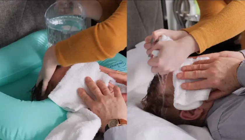 Demostración de cómo lavar el pelo a una persona encamada con una tina inflable y toallas.